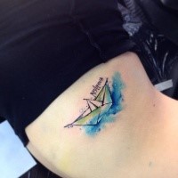 Small watercolor style biceps tattoo of paper ship with lettering