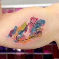 Small watercolor style colored biceps tattoo of baby foot print
