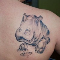 Smiling gray-ink hippo head tattoo on upper back