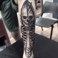 Smiling skull on skeleton black and white leg tattoo with dark shadow