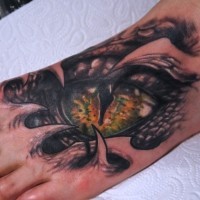 Tatuaggio pauroso sul mano l'occhio del serpente