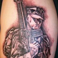 Soldier with gun tattoo on arm
