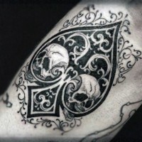 Spades symbol stylized with skulls and ornaments black and white tattoo