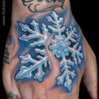Funkelnde farbige detaillierte Schneeflocke Tattoo an der Hand mit Schriftzug