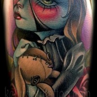 Tatuaje en el brazo, mujer misteriosa con la cara azul y muñeco de peluche
