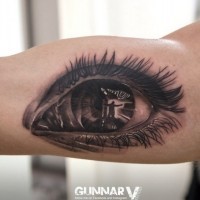 Spectacular black and white human eye tattoo on biceps
