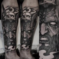 Spectacular black ink arm tattoo of demonic man with human skull