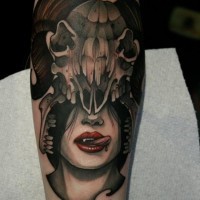 Tatuaje en el antebrazo,
mujer vampiro con casco de cráneo de oveja
