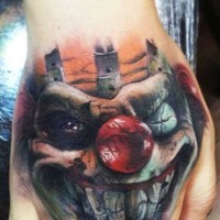 Spooky clown with red nose tattoo on hand