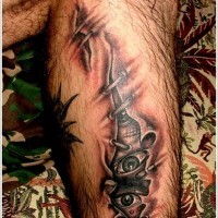 Spooky eyes under skin rip tattoo on leg