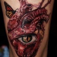 Tatuaggio sulla gamba il cuore con l'occhio e le farfalle