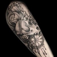 stippling style black ink arm tattoo of animal skull with flowers and dream catcher