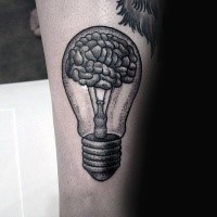 Stippling style black ink arm tattoo of bulb with human brain