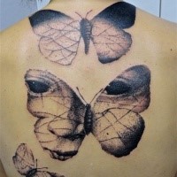 Stippling style black ink back tattoo of butterflies stylized with human eyes