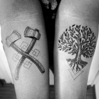 Stippling style black ink forearm tattoo of tree with crossed axes