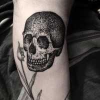 Stippling style black ink leg tattoo of human skull and flowers