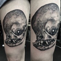 Stippling style black ink thigh tattoo of monster skull