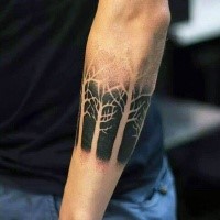 Stippling style black ink typical forearm tattoo of forest