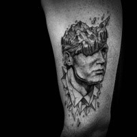 Stonework style black ink arm tattoo of man head with stone