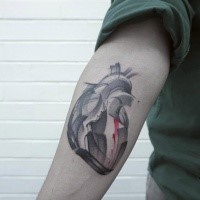 Stonework style colored arm tattoo of human heart