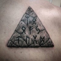 Stonework style colored back tattoo of big pyramid and lettering