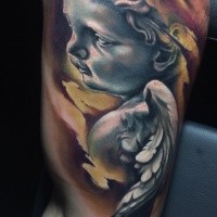 Stonework style colored biceps tattoo of small baby angel statue