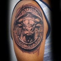 Stonework style colored shoulder tattoo of Taurus with lettering