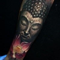 Stonework style forearm tattoo of Buddha statue and lotus flower