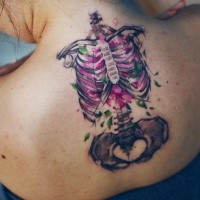 Strange colored upper back tattoo of woman skeleton with flowers