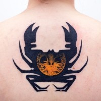Strange designed black ink crab tattoo on upper back stylized with mystical symbol