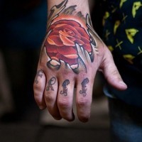 Seltsame rot gefärbte glühende Rose Tattoo an der Hand mit Schriftzug
