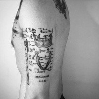 Strange looking black ink arm tattoo of various bones and pictures