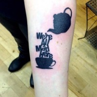 Tatuaje en el antebrazo,
tetera con taza de té, tinta negra