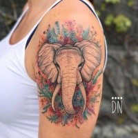 Stunning colored by Dino Nemec upper arm tattoo of elephant head with flowers