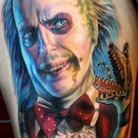 Stunning colored horror style large thigh tattoo of creepy clown with alien like snake