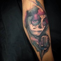 Tatuaje en el antebrazo, mujer santa muerte con micrófono