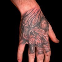 Stunning old school designed hand tattoo of creepy monster face