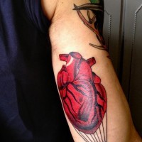 bel dipinto colorato cuore volante come mongolfiere tatuaggio su braccio