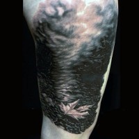 Stunning painted black and white little maple leaf in fog shoulder tattoo