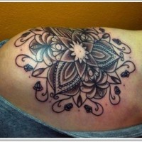 Stylized black lotus tattoo on shoulder
