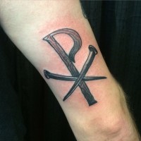 Tatuaje en el brazo, cristograma formado de madera y clavos