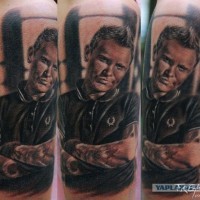 Tatuaje en el brazo, retrato realista de hombre encantador