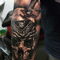 Tatuaje en el antebrazo,
cráneo tremendo perforado por la espada