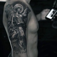 Tatuaje en el brazo, ángel guerrero hermoso impresionante y inscripción