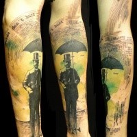 Surrealism style colored arm tattoo of man with umbrella and lettering