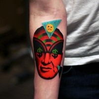 Surrealism style colored forearm tattoo of human face with various symbols and smiley face