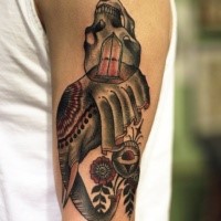 Surrealism style colored shoulder tattoo of elephant shaped head with skull and flowers
