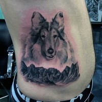 Süßer  schwarzweißer Hund und Berge Tattoo an der Seite