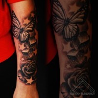 bellissimo dipinto bianco e nero farfalla con dadi e fiore tatuaggio avambraccio