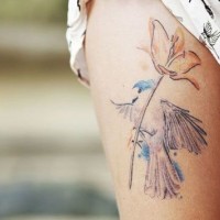 Sweet painted watercolor like big bird with flower tattoo on thigh